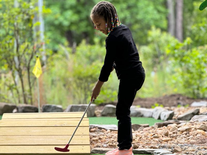 Child playing mini golf at Putt Forest in Raleigh North Carolina